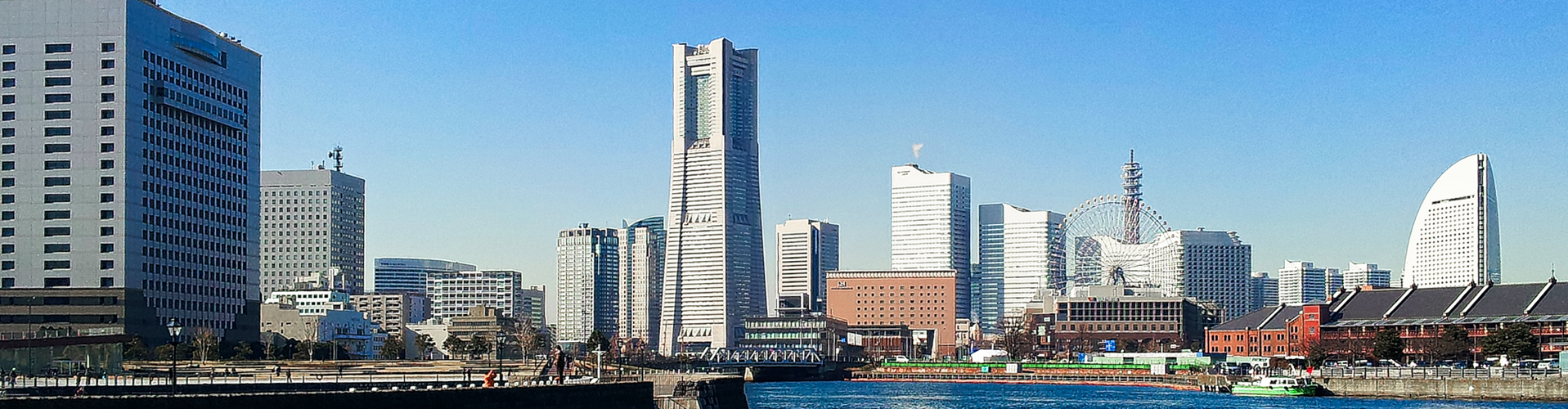 横浜のスカイライン、左にランドマークタワー、中央に大観覧車、右にインターコンチネンタルホテルが並ぶ青空の都市風景